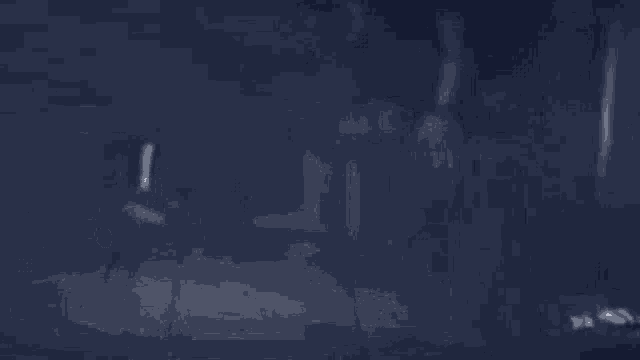 a person is holding a sword in the dark .