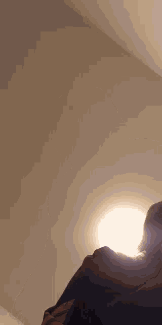 a person standing in front of a wall with a light shining on them .