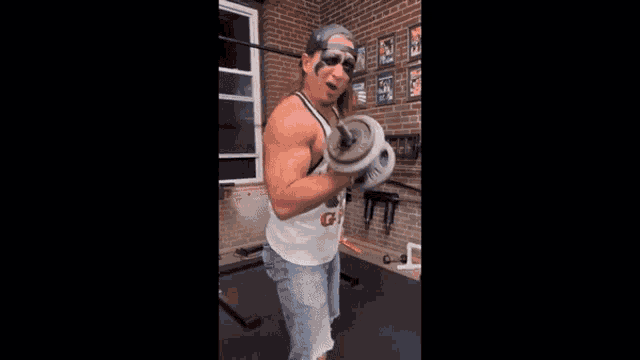 a man is lifting a dumbbell in a gym with the words warhorse is behind him