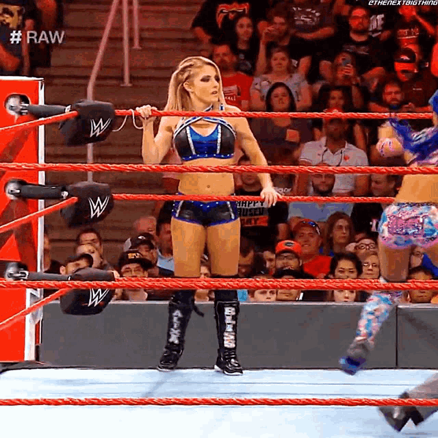 a woman in a wrestling ring with #raw on the bottom