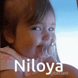 a baby with a pacifier in her mouth and the name niloya on the bottom