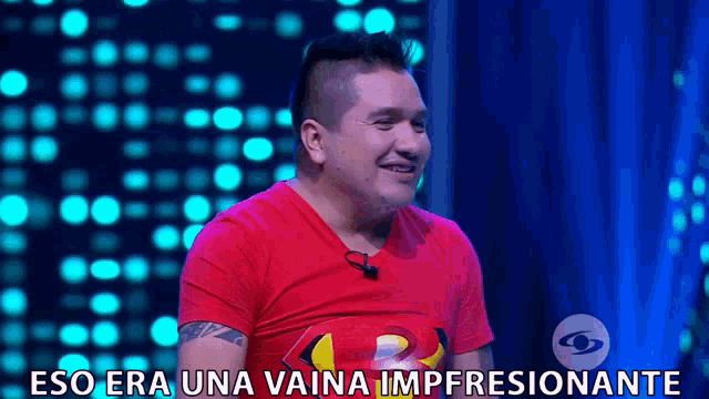a man wearing a red shirt with the words eso era una vaina impresionante