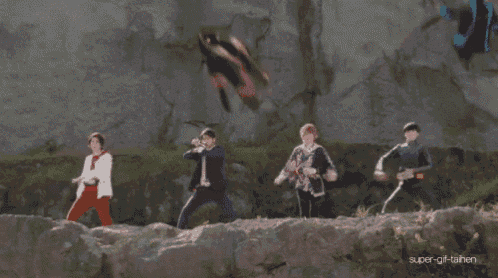 a group of people standing on top of a rocky cliff with super-gif-tainen written in the corner
