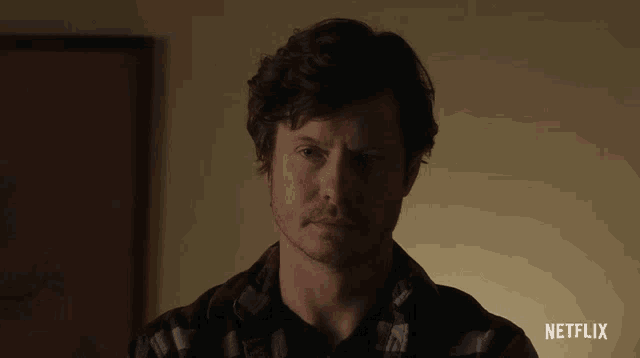 a close up of a man 's face with a netflix advertisement in the corner
