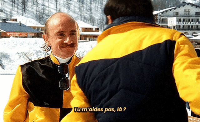 a man in a yellow jacket is talking to another man in a black jacket