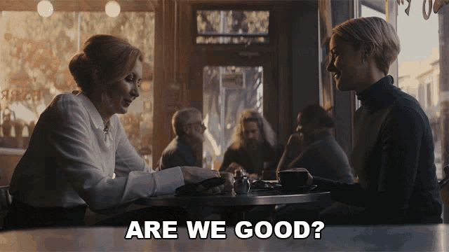 two women are sitting at a table with the words are we good on the bottom