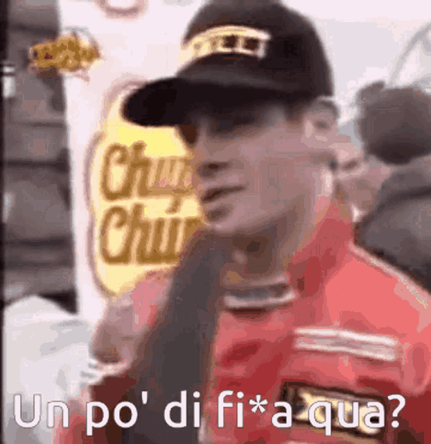 a man wearing a red jacket and a black hat with the words un po ' di fi * a qua written on it