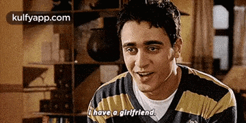 a man in a striped sweater is talking to a woman .