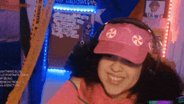 a girl wearing headphones and a pink hat with candy on it