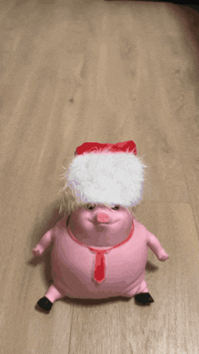 a pink stuffed animal is crawling on a wood floor
