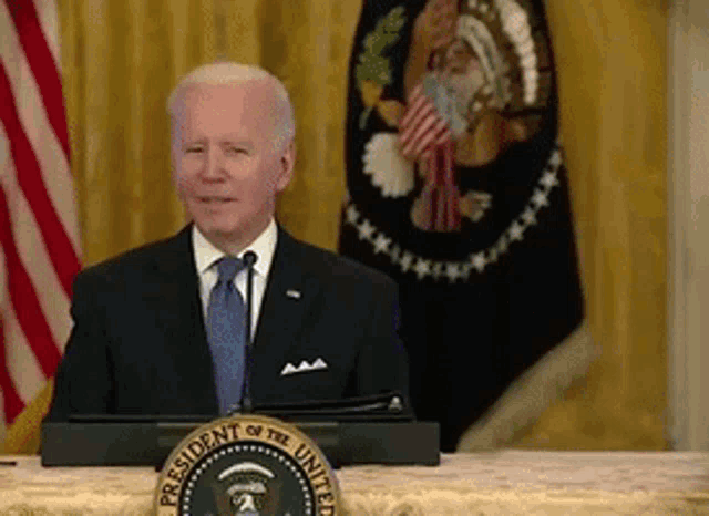 the president of the united states is standing at a podium