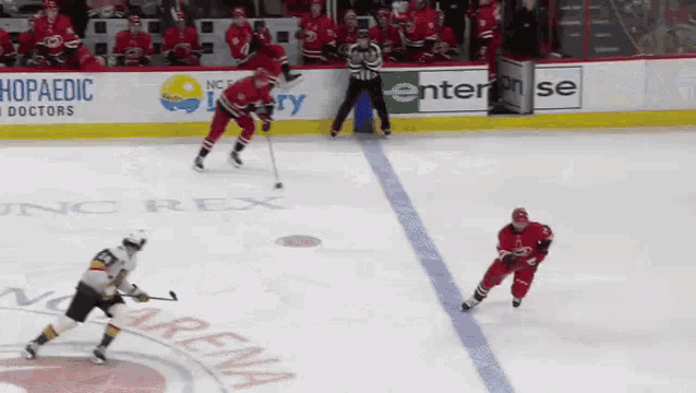 a hockey game is being played in front of a sign that says enterprise