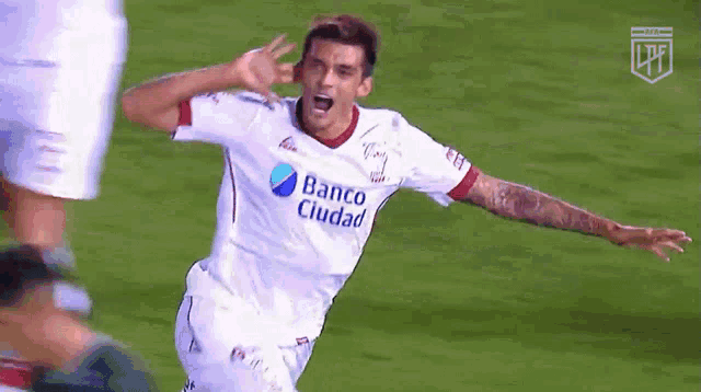 a man in a banco ciudad jersey celebrates