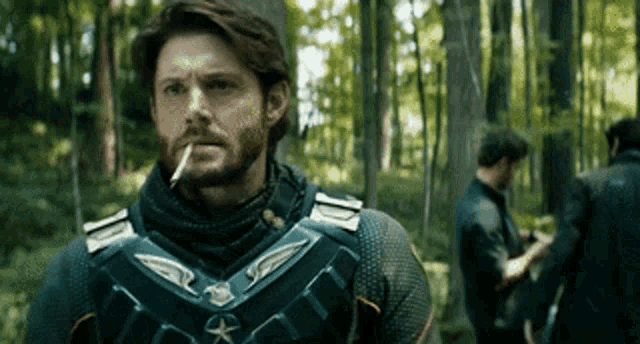 a man is smoking a cigarette in the woods .