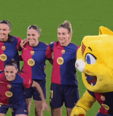 a group of female soccer players pose for a picture with a mascot