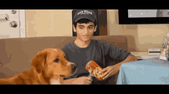a young man wearing a san diego hat holds a bag of chips