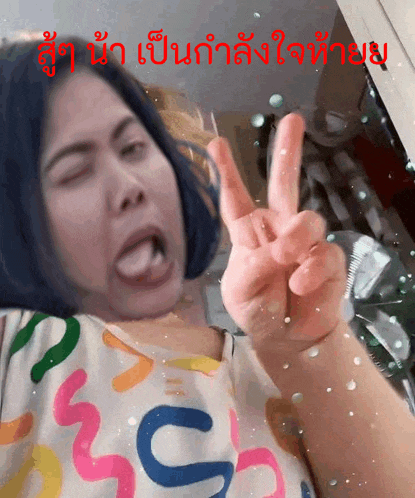 a woman making a funny face and giving a peace sign in a foreign language