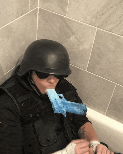 a person wearing a helmet and sunglasses is holding a blue toy gun in their mouth