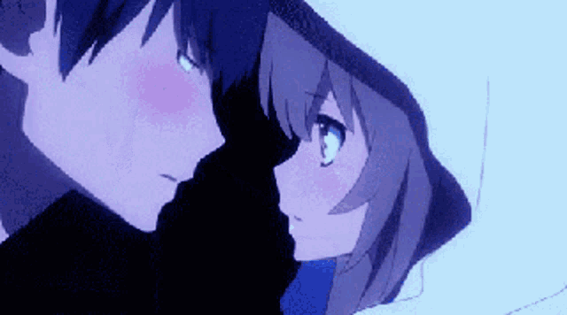 a boy and a girl are looking at each other and kissing in the snow .