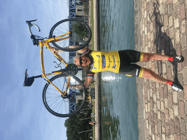 a person holding a yellow bike with the word trek on the front