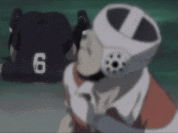 a person wearing a helmet with the number 6 on it is talking on a cell phone .