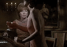 two women are standing next to each other in a room .