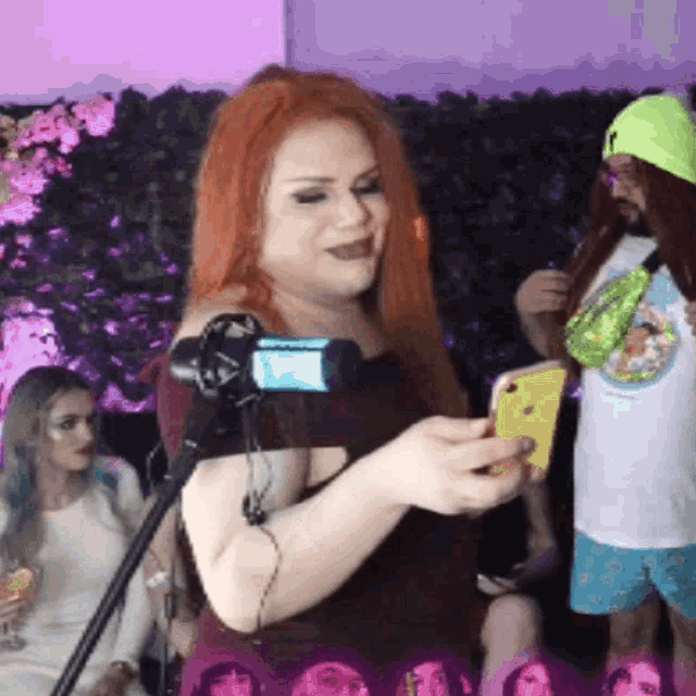 a woman with red hair is taking a picture of herself in front of a camera
