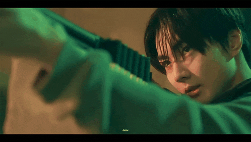 a close up of a young man holding a gun in his hand .
