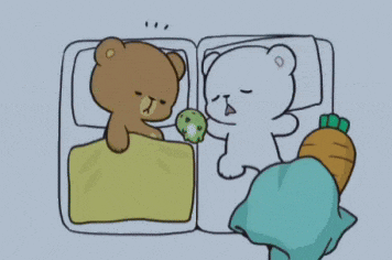 two teddy bears are sleeping next to each other with a carrot in their paws