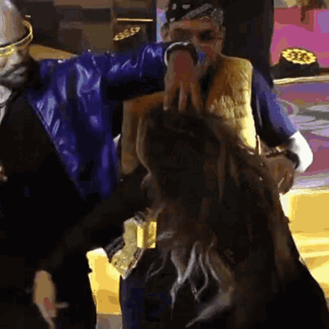 a man in a blue jacket holds a woman 's hair