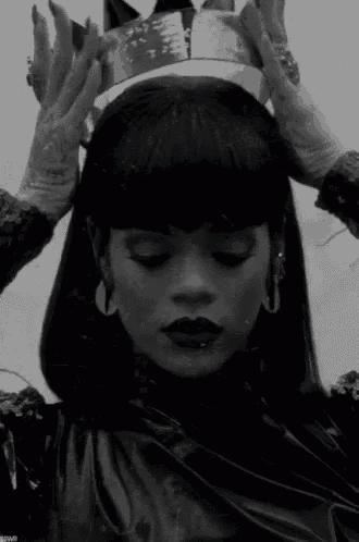 a black and white photo of a woman wearing a crown .