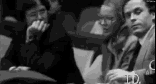 a group of people are sitting in a row in a room .