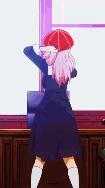 a girl with pink hair is standing in front of a window wearing a red hat and a black dress .