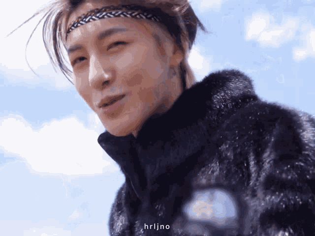 a man wearing a fur coat and a headband with the word hrljno below him