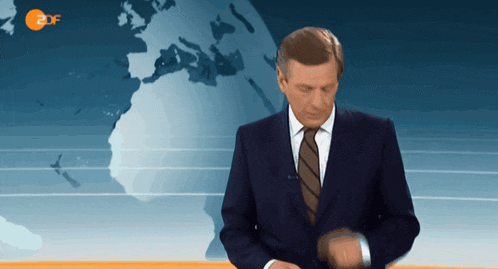 a man in a suit and tie is standing in front of a map with 2df written on it