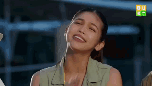 a woman is making a funny face while wearing headphones and smiling .