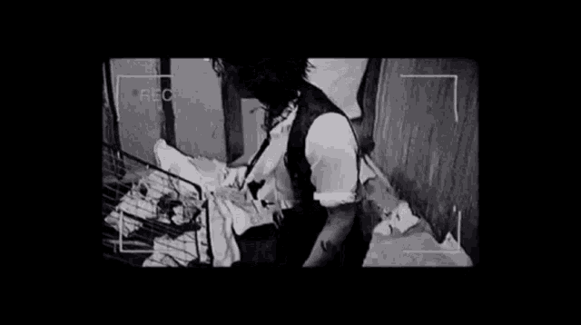 a black and white photo of a man with blood on his face standing next to a cage .