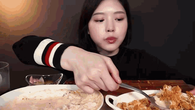a woman is eating a plate of food with a fork