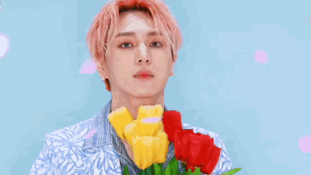 a man is blowing a kiss while holding a bouquet of flowers .