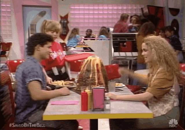 a man and a woman are sitting at a table in a diner with the hashtag saved by the bell