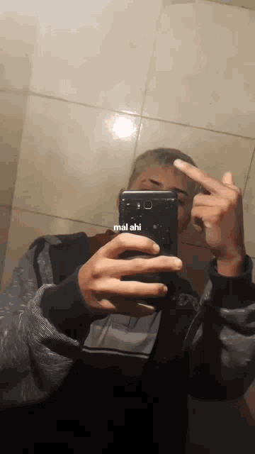 a man is taking a picture of himself in a mirror with the words mai ahi on the bottom right