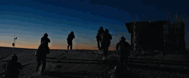 a group of people standing on top of a snow covered hill at night