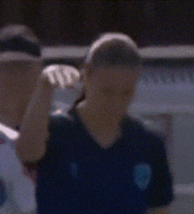 a blurry picture of a man wearing a blue shirt with a s on it