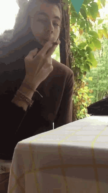 a man is sitting at a table smoking a cigar