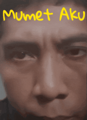 a close up of a man 's face with the words " mumet aku " written on it