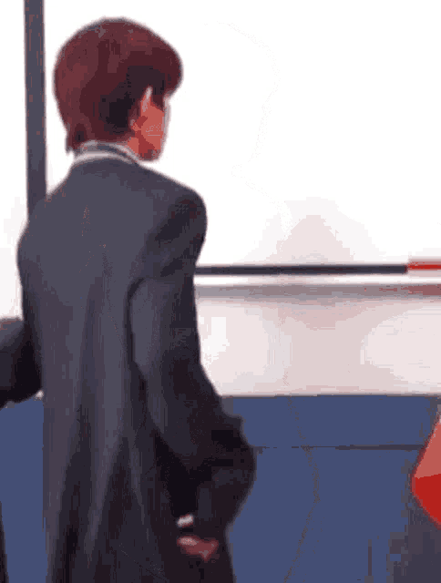 a person in a suit is standing in front of a white board .