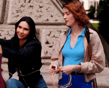 two women are standing next to each other with a tnt logo in the background