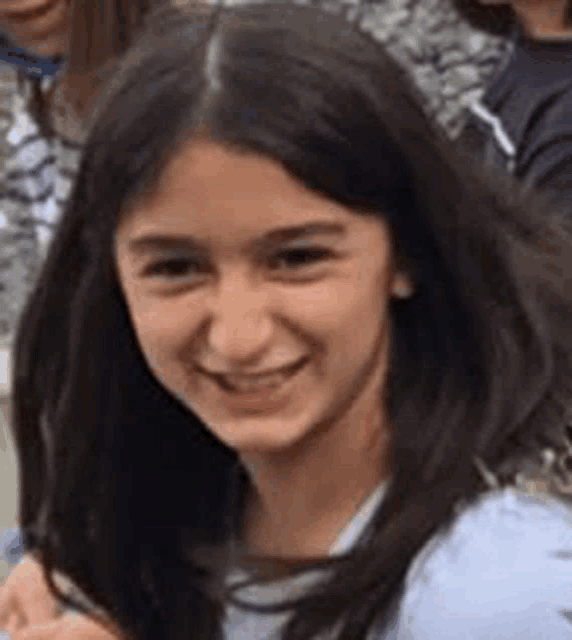 a close up of a girl with long hair smiling .