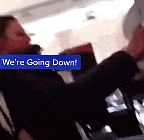 a blue sign that says we 're going down is above a person