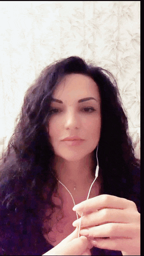 a woman wearing ear buds looks at the camera